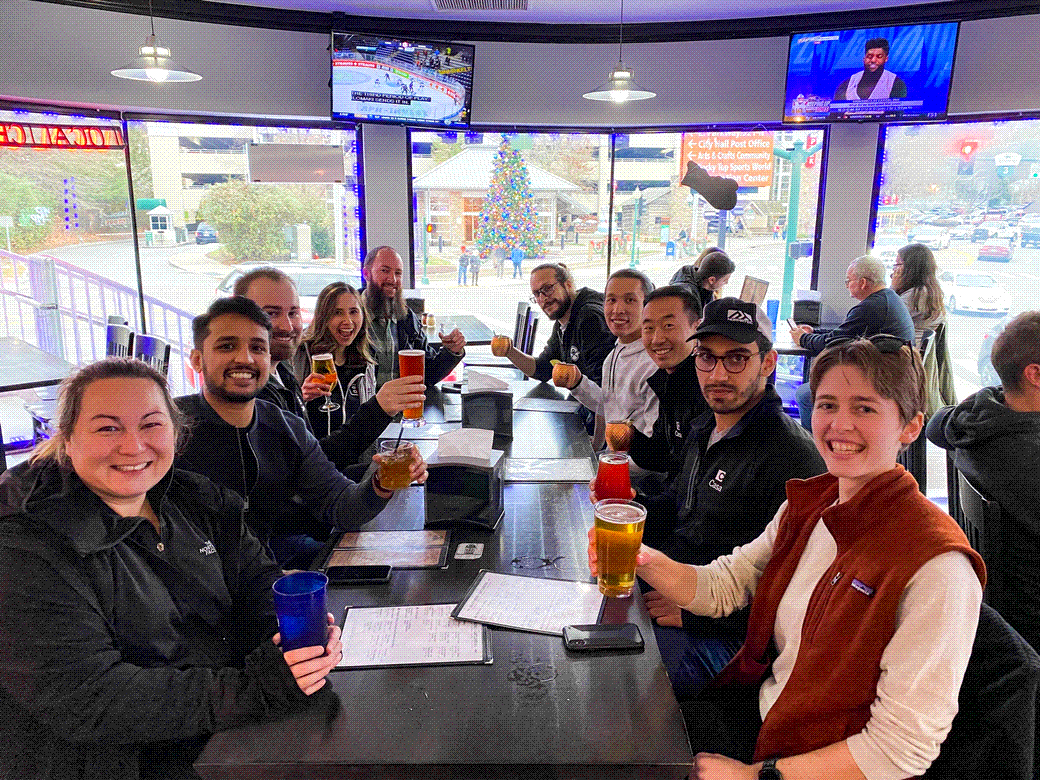 Casa team members raising a glass around a table